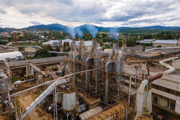 Vista aérea de la planta de procesamiento de madera con chimenea del proceso de producción que contamina el medio ambiente en el patio de fabricación de la fábrica