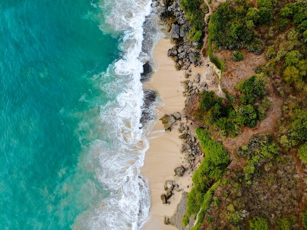 Vista aérea playa de arena con rocas y acantilado verde vista superior de una hermosa playa de arena con rocas