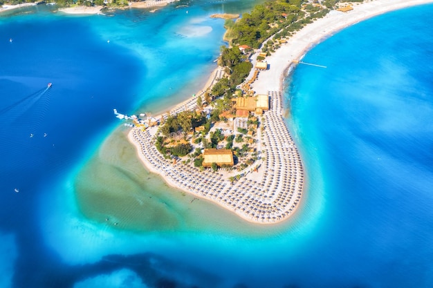 Vista aérea de la playa de arena con sombrillas bosque verde en un día soleado en verano Laguna azul en Oludeniz Turquía Paisaje tropical con isla de la bahía del mar banco de arena blanca agua azul Vista superior Naturaleza