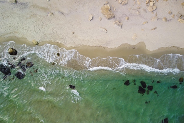 Vista aérea de la playa rocosa y las olas del mar