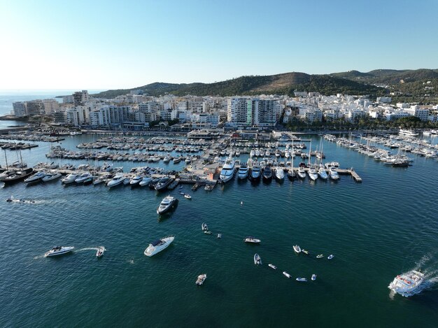 Foto vista aérea de pontones llenos de barcos y veleros en el puerto deportivo frente a la ciudad