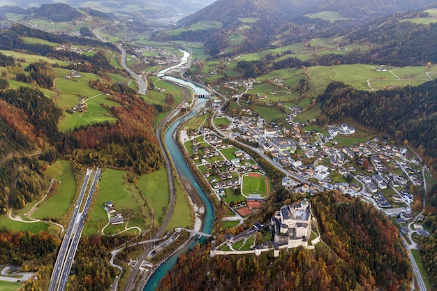 Vista aérea de prados verdes con pueblos y bosques en las montañas de los Alpes austríacos.