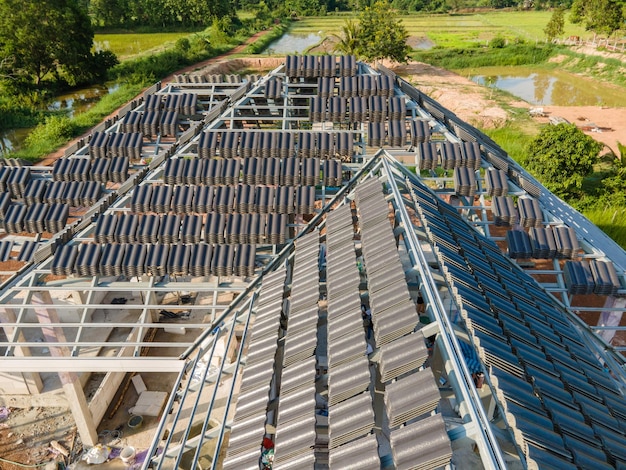 Vista aérea de Durante la preparación previa al techo de tejas de hormigón o cemento CPAC en la nueva estructura del techo en construcción edificio residencial