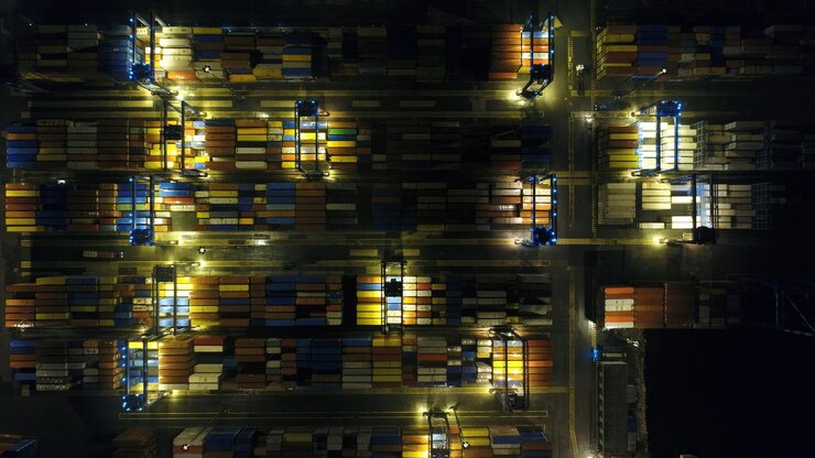 Foto vista aérea del proceso de carga y descarga de buques contenedores en el puerto comercial por la noche
