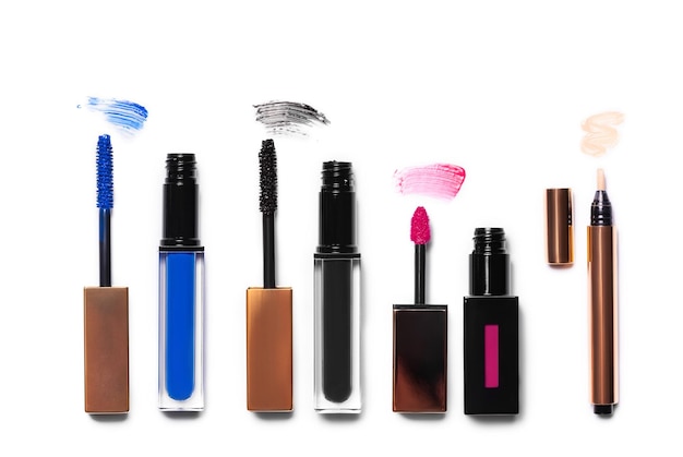 Vista aérea de productos cosméticos de belleza que se derraman sobre un fondo blanco