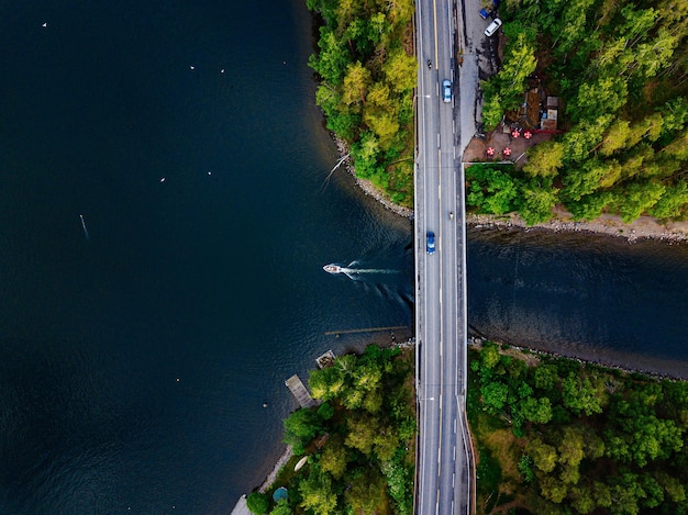 Vista aérea del puente con un barco que pasa por debajo Lago azul con casas de verano en la Finlandia rural