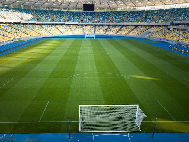 Vista aérea desde las puertas de fútbol del dron en el estadio verde con las gradas amarillo-azul del Complejo Deportivo Nacional Olímpico.