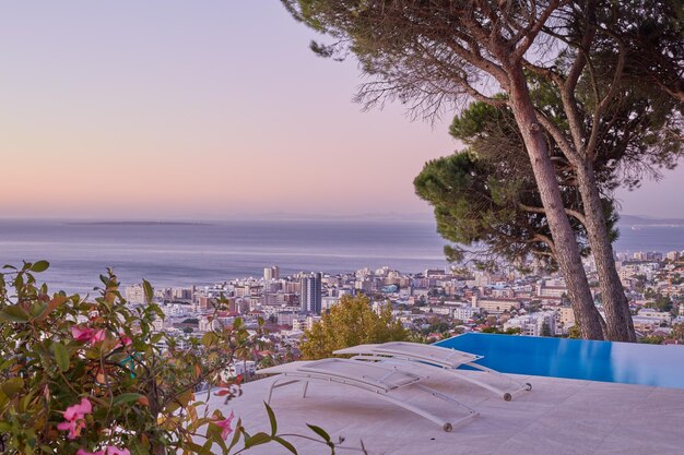 Vista aérea del punto marítimo de Ciudad del Cabo durante la puesta de sol El hermoso panorama paisajístico de Sudáfrica con espacio de copia y horizonte marino tocando el cielo Vista panorámica de una ciudad con rascacielos y árboles