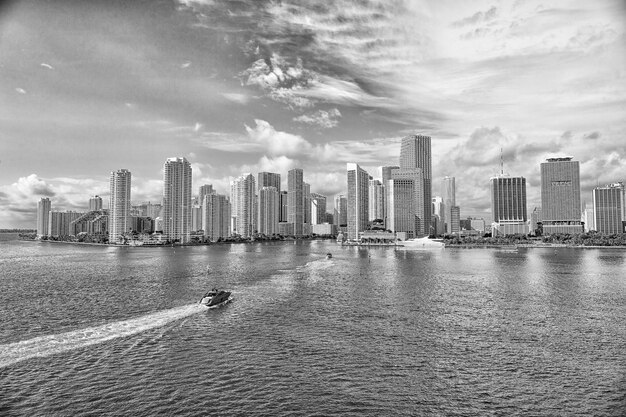 Vista aérea de los rascacielos de Miami con un barco azul cielo nublado navegando junto al centro de Miami