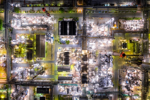 La vista aérea de la refinería de petróleo y la planta de la refinería de gas forman zona de la industria en la noche.