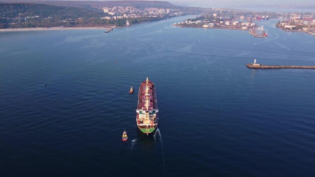 Vista aérea del remolcador que ayuda a un gran buque de carga granelero Gran buque escoltado por un remolcador