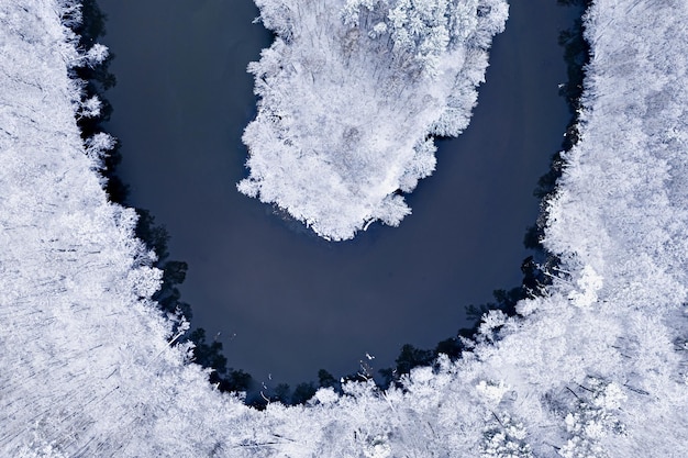 Vista aérea del río con curvas y el bosque congelado en invierno