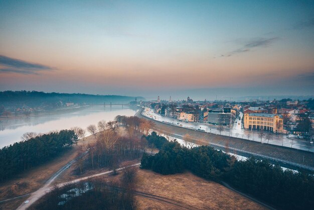 Vista aérea del río por los edificios de la ciudad durante la puesta de sol