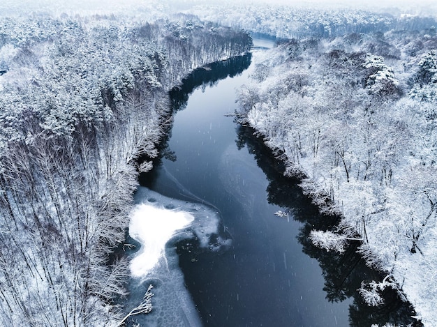 Vista aérea del río frío y el bosque nevado en invierno