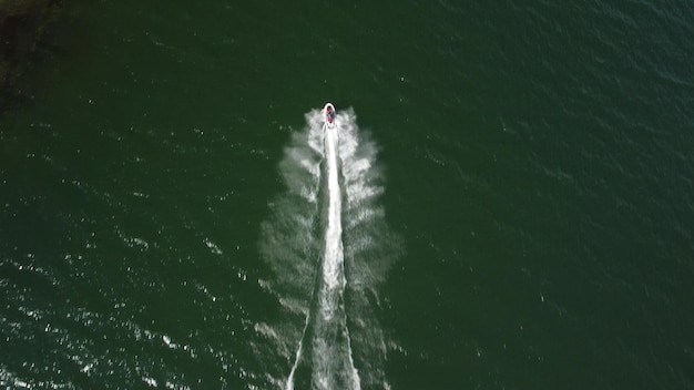 Vista aérea de un scooter en la superficie del lago Barco flotante de lujo en el agua en un día soleado