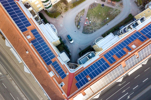 Vista aérea del sistema de paneles fotovoltaicos solares en el techo del edificio de apartamentos. concepto de producción de energía verde ecológica renovable.