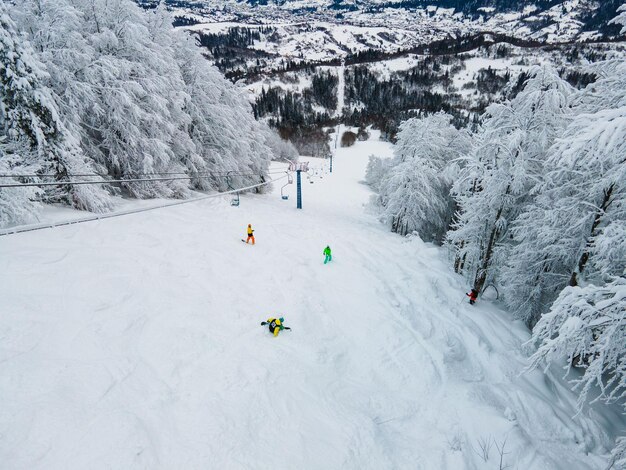 Vista aérea de snowboarders free riders en pistas de esquí ucrania montañas de los cárpatos