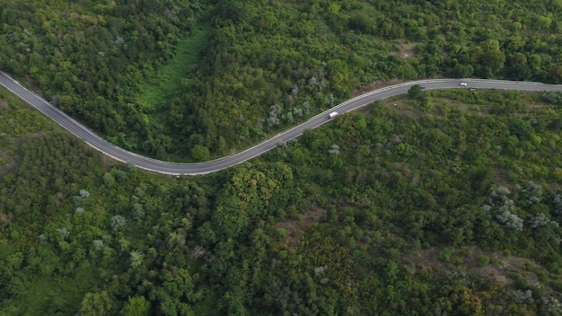 Vista aérea sobre a floresta com uma estrada passando com carro