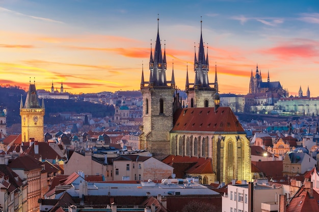 Vista aérea sobre a igreja de nossa senhora antes da cidade velha de tyn e do castelo de praga ao pôr do sol em praga tcheca