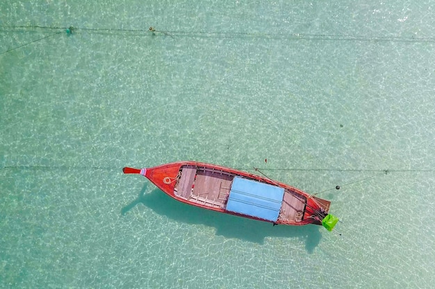 Vista aérea sobre bote de cola larga con hermoso mar y playa