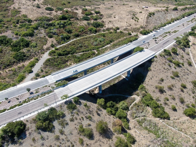 Vista aérea de los soportes del viaducto del puente de carretera en el valle entre las colinas amarillas secas