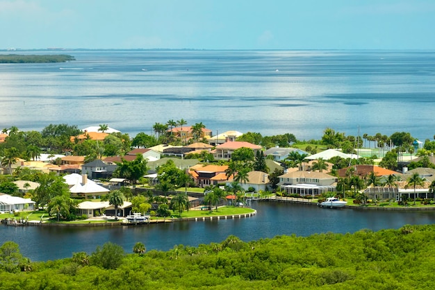 Vista aérea de suburbios residenciales con casas de un piso ubicadas cerca de humedales de vida silvestre con vegetación tropical verde en la orilla del mar Vivir cerca de la naturaleza en un concepto de clima cálido