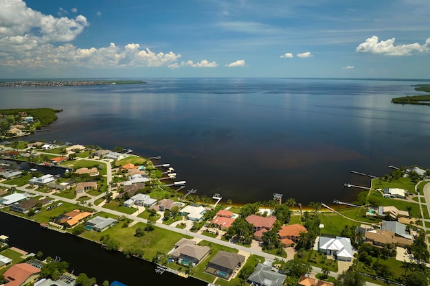 Vista aérea de suburbios residenciales con casas de un piso ubicadas cerca de humedales de vida silvestre con vegetación tropical verde en la orilla del mar Vivir cerca de la naturaleza en un concepto de clima cálido