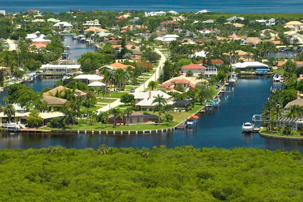 Vista aérea de los suburbios residenciales con casas privadas ubicadas cerca de humedales de vida silvestre con vegetación verde en la orilla del mar Concepto de vida cerca de la naturaleza