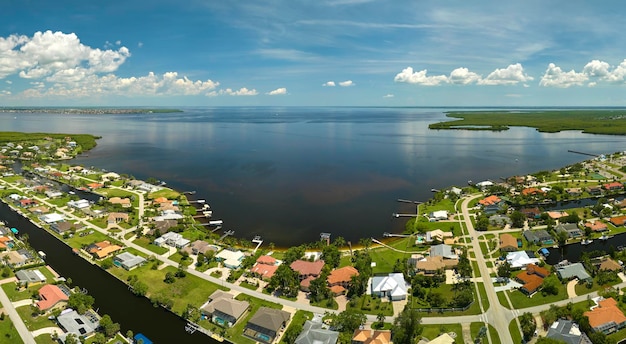 Vista aérea de suburbios residenciales con casas privadas ubicadas en la costa del golfo cerca de humedales de vida silvestre con vegetación verde en la orilla del mar Concepto de vida cerca de la naturaleza