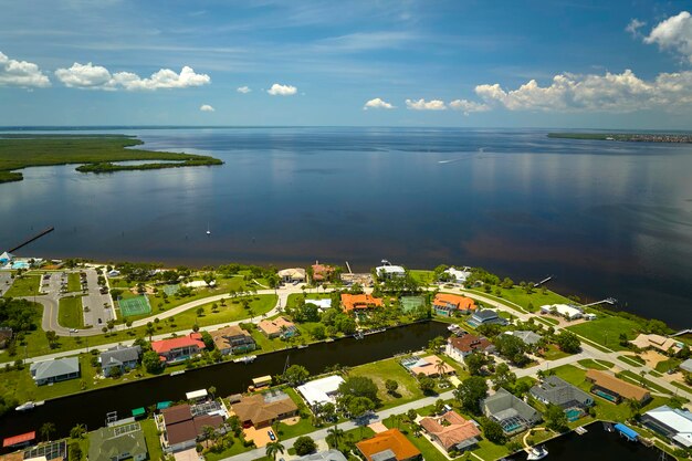 Vista aérea de suburbios residenciales con casas privadas ubicadas en la costa del golfo cerca de humedales de vida silvestre con vegetación verde en la orilla del mar Concepto de vida cerca de la naturaleza