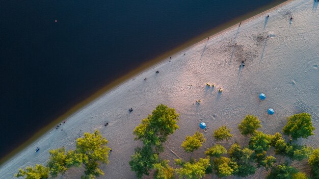 Vista aérea superior del agua del río Dnieper y playa de arena desde arriba