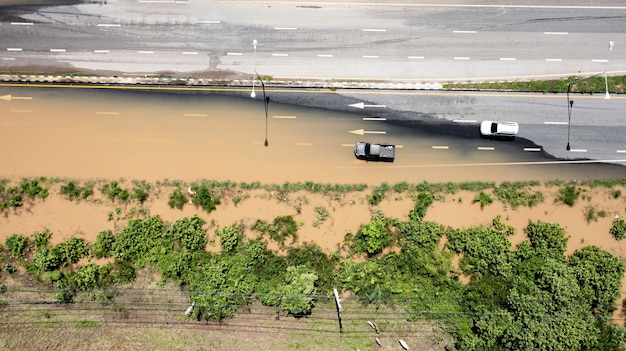 Vista aérea superior de la aldea inundada y la carretera rural con coche, vista desde arriba tomada por drone