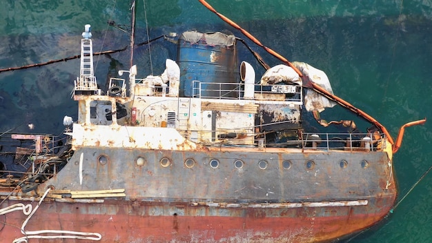 Vista aérea superior del buque petrolero oxidado roto volcado después de que el naufragio ahogó el barco hundido en th