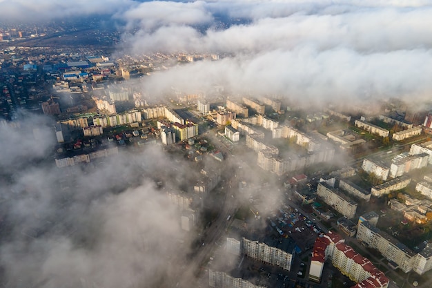 Vista aérea superior de esponjosas nubes blancas sobre la ciudad moderna con edificios de gran altura.