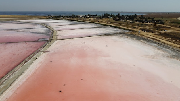 Vista aérea superior del hermoso lago salado con agua rosada. Vista del lago rosa desde drone volador. Fotografía de helicóptero de abejón desde arriba. Paisaje con zumbido