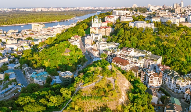 Vista aérea superior de la iglesia de San Andrés y la calle Andreevska desde arriba, paisaje urbano del distrito de Podol al atardecer, horizonte de la ciudad de Kiev (Kiev), Ucrania