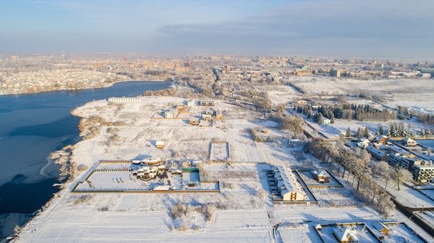 Vista aérea superior de invierno arriba vista por encima de la vida rural lenta por un pequeño río.