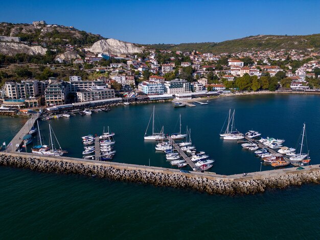 Vista aérea superior de un puerto deportivo junto al mar adornado con elegantes yates que crean una pintoresca escena marítima