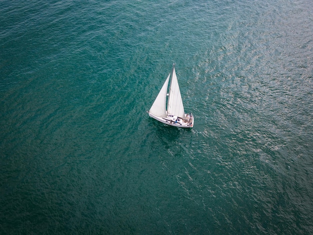 Vista aérea superior de un velero deslizándose con gracia a través de las ilimitadas olas del mar