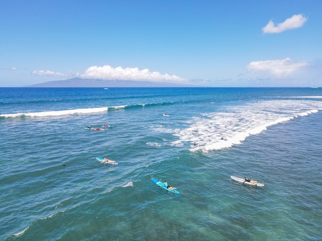 Vista aérea de surfistas y olas en el océano azul cristalino en Maui Hawaii USA