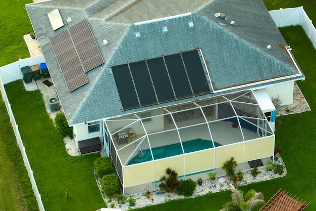 Foto vista aérea del techo de una casa estadounidense regular con paneles solares fotovoltaicos azules para producir energía eléctrica ecológica limpia invertir en electricidad renovable para los ingresos de jubilación