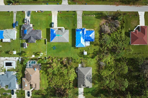 Vista aérea de los techos de las casas dañados por el huracán Ian cubiertos con una lona protectora azul contra la fuga de agua de lluvia hasta el reemplazo de las tejas de asfalto