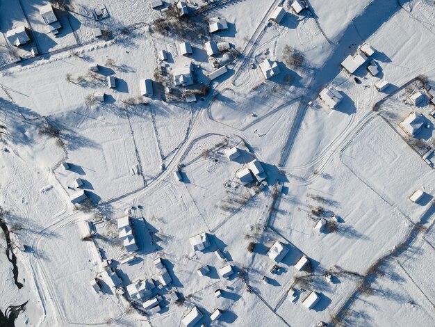 Vista aérea de techos cubiertos de nieve sobre los chalés tradicionales en el pueblo de alpes.