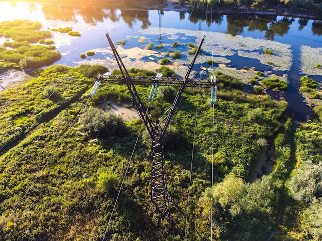 Vista aérea de un tendido eléctrico con un río y árboles al fondo