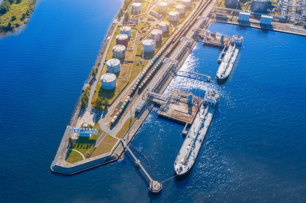Vista aérea terminal de carga de petróleo de gran puerto con grandes tanques de almacenamiento Infraestructura ferroviaria para la entrega de carga a granel por mar