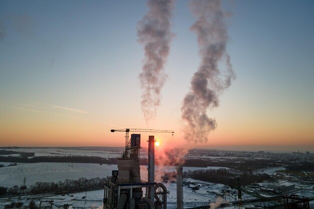 Vista aérea de la torre de la fábrica de cemento con estructura de planta de hormigón alto en el área de producción industrial al atardecer Fabricación y concepto de industria global