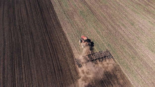 Vista aérea del tractor agrícola arando y fumigando en el campo Agricultura Vista desde arriba Foto ca