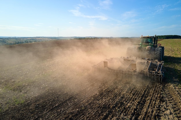 Vista aérea del tractor arando el campo de la granja agrícola preparando el suelo para sembrar en verano