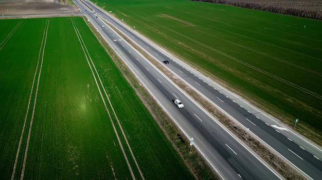 Vista aérea del tráfico en la carretera de dos carriles a través del campo y campos cultivados