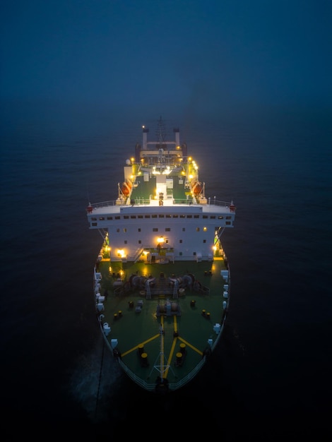 Vista aérea de un transbordador que navega a través de condiciones de niebla en la noche en el mar